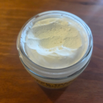 Open jar of Greene Grass Vanilla & Honey whipped tallow moisturizer showing its real texture.