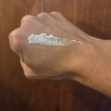 A smear of Greene Grass Vanilla & Honey whipped tallow moisturizer on the back of a hand before rubbing it in.